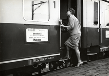 169789 Afbeelding van een vrouw die instapt in de internationale trein Rheingold op het N.S.-station Amsterdam Amstel ...